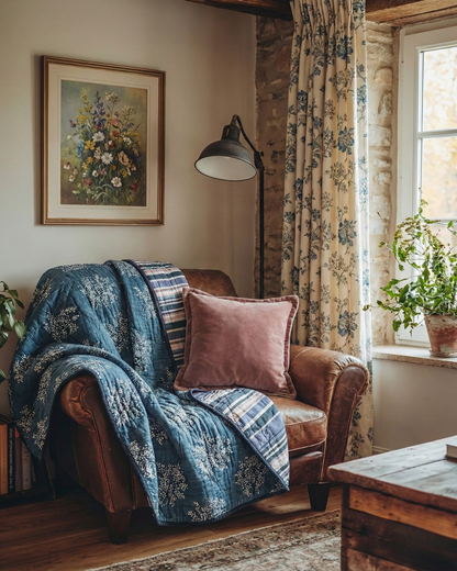Cozy living room with a brown armchair covered by a midnight Ode Tree Quilt & Velvet Sand Triple Edge cushion and framed artwork on the wall.